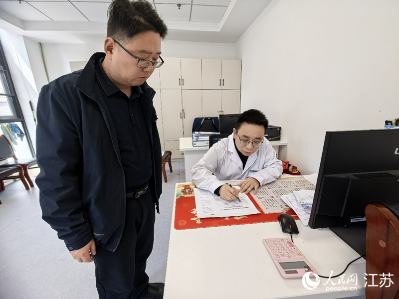 海门街道社区卫生服务中心工作人员帮患者填写个性化用药采购清单。人民网记者 王继亮摄