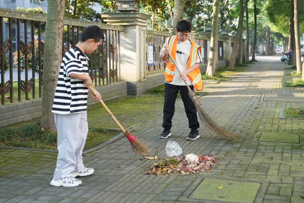 “我帮妈妈扫大街”——小手握扫帚 温情暖街头