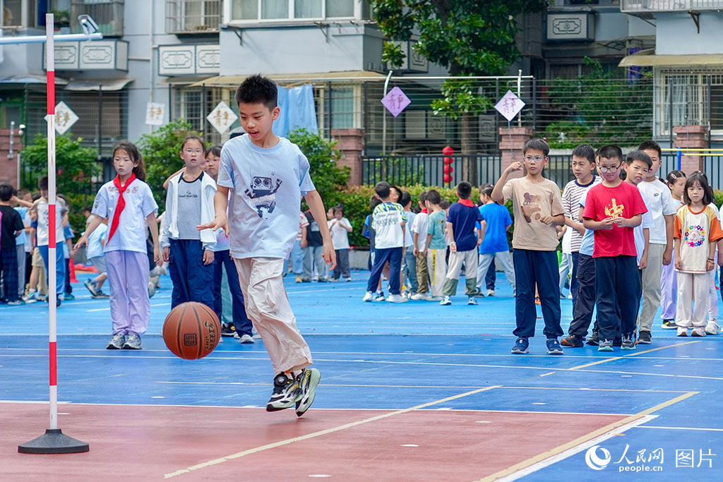 2026年5月27日，浙江杭州长寿桥小学的孩子们在操场上打篮球。奔跑、传球、投篮，笑声与脚步声交织成一片。人民网记者 郭扬摄