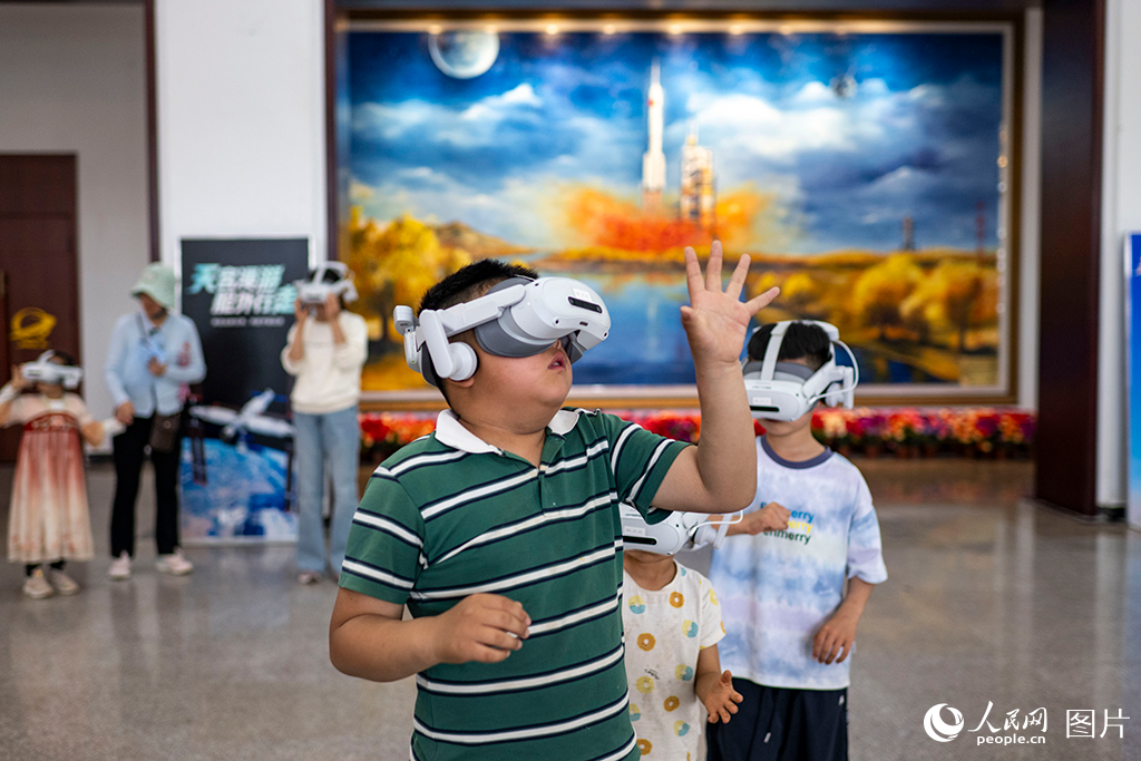 2026年5月23日，在酒泉卫星发射中心的科普活动现场，孩子们正通过VR设备体验太空探索，感受星辰大海的壮阔。人民网记者 翁奇羽摄